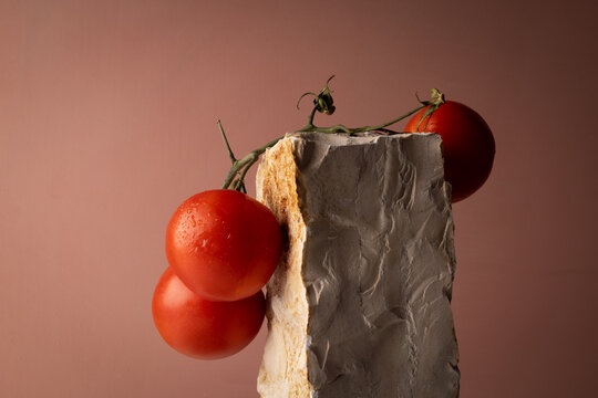 Natura morta con pomodori rossi su pietre naturali, composizione minimalista con spazio per il testo