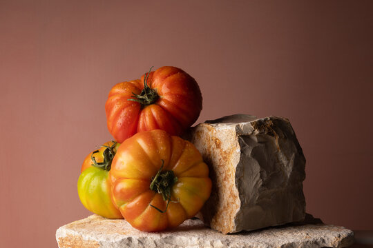 Pomodori costoluti di variet&agrave; antica su lastre di pietra naturale, natura morta con spazio per il testo