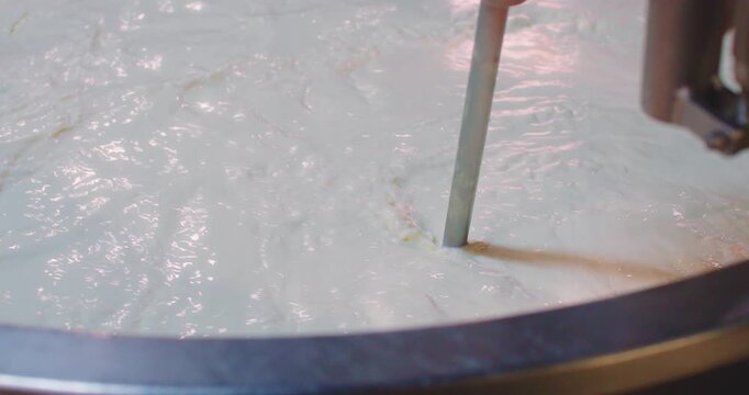 Slow Motion Of Professional dairy mixer processing fresh milk inside a large copper vat in a cheese factory. Industrial Mixer Processing Fresh Milk in Copper Cheese Vat