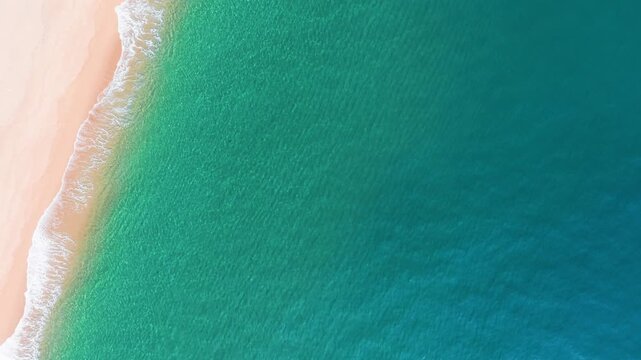 People walk along Bien Lo Quang beach in Vietnam. The clear water meets the soft sand under sunlight. Waves gently wash up on the shore, creating a nice view for visitors.