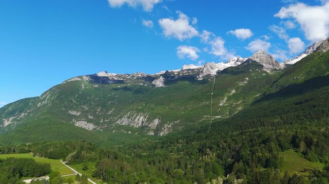 Imposing Kanin mountain range above Bovec alpine town in Slovenia. Aerial riser