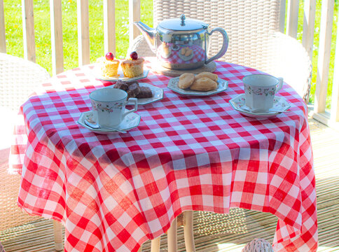 Summer Garden Afternoon Tea with Fresh Croissants on Gingham Tablecloth &ndash; Relaxed Al Fresco Holiday Lifestyle