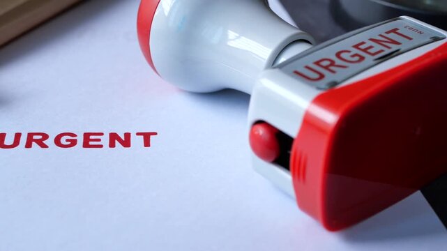 Close up of red urgent stamp on white paper with copy space