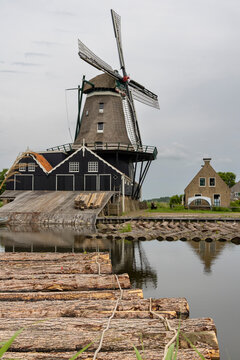 Historic saw windmill by a canal in IJlst Friesland Netherlands reflecting traditional Dutch rural life and tourism appeal