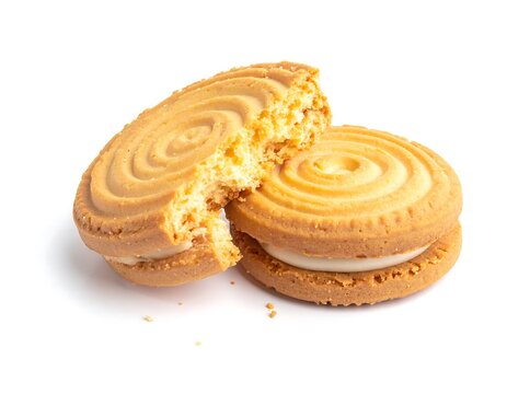 A pair of round, golden-brown cookies with white filling and spiral designs, one broken