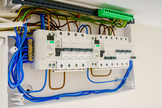 Angle view of an open electrical panel with RCD safety devices and circuit breakers. Modern domestic consumer unit showing colorful organized wiring during installation or home renovation.