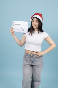 Smiling young girl in red santa hat holding a small white blank card