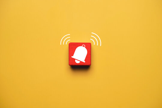 Notification alert concept with a ringing bell icon on a wooden block, representing reminders, announcements, alerts, communication, mobile notifications, user engagement and digital messaging.