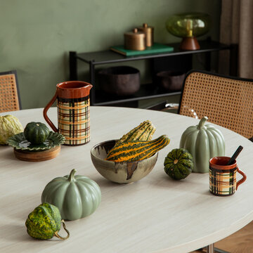 Autumnal Table Decor with Varied Gourds and Plaid Ceramics in a Cozy Interior Setting