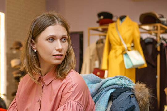 Woman Carrying Several Coats While Shopping in a Boutique