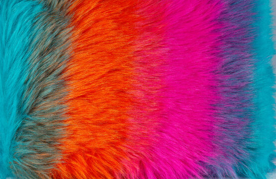 Colorful fur fabric in shades of blue, orange, pink, and purple displayed on a flat surface