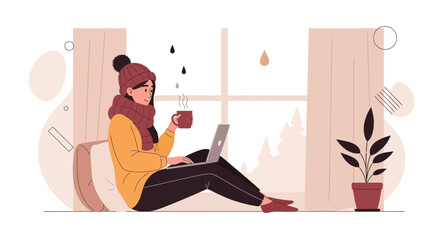 Fototapeta premium Cozy Winter Scene: Woman Working on Laptop with Hot Drink by the Window