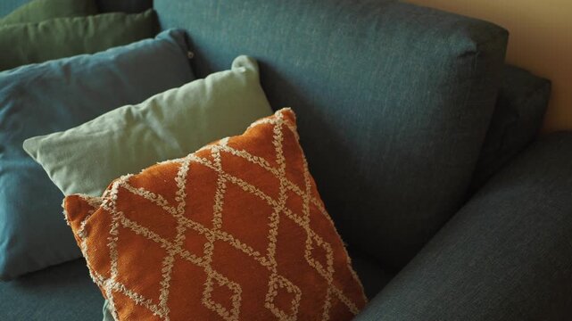 Close up camera movement on colorful pillows on couch, providing a cozy and inviting atmosphere for relaxation and comfort