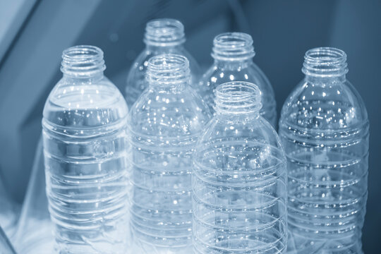Close-up of a group of transparent plastic bottles for drinking water in a mass production process.