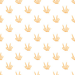 Fototapeta premium Skeleton hand showing peace or victory sign creating a halloween seamless pattern