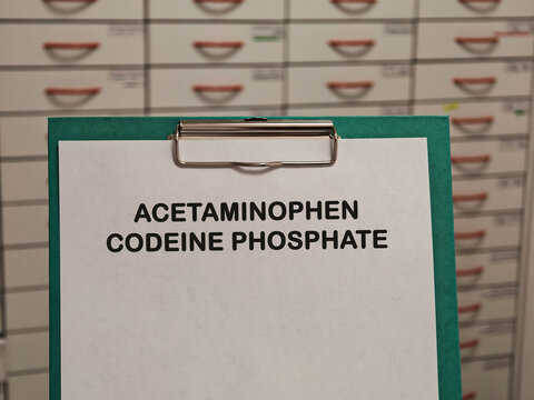 ACETAMINOPHEN CODEINE PHOSPHATE analgesic combination medicine for pain fever and symptom relief displayed on a clipboard in a pharmacy healthcare concept