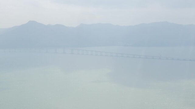 aerial view from flying airplane above sea coast ocean in Hongkong while airplane approaching landing to Hongkong Airport with some fog cloud in sky