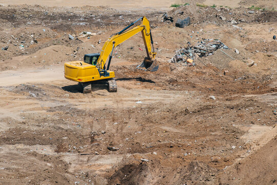 A yellow excavator is working at a construction site