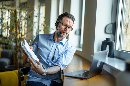 Mature man working remote and teaching online during video call