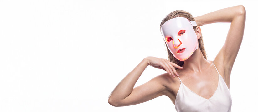 A woman in LED facial mask with graceful hand poses, space for text. Cosmetology concept, and beauty device, woman advertising facial anti age lift products salon care tighten skin, isolated