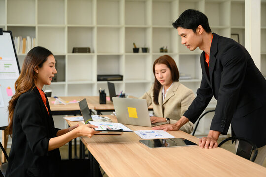 Asian Business People Having a Team Meeting in Modern Office Discussing Reports and Documents