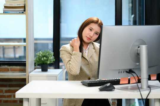 Asian Businesswoman Experiencing Neck Pain at Office Desk After Failed Planning Meeting Strategy Session