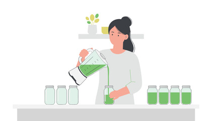 Fototapeta premium Woman pours a healthy green smoothie from a blender into several glass storage jars on a kitchen counter for meal preparation.