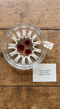Blood Donation Concept: Red Drops in Glass Dish with Supportive Message Symbolizing Healthcare Aid