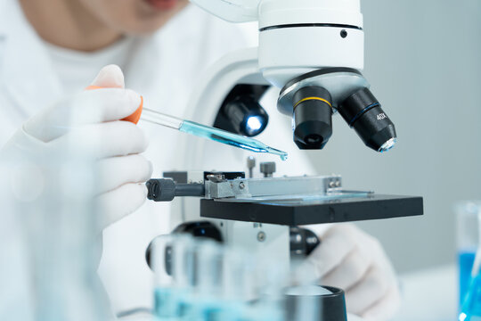 Scientist analyze biochemical samples in advanced scientific laboratory. Medical professional use microscope look microbiological developmental of viral. Biotechnology research in science lab.