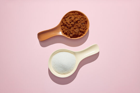Muscovado sugar and white granulated sugar side by side on pink background