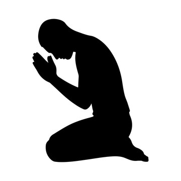 Silhouette of a male figure kneeling and praying with hands clasped together in side profile view
