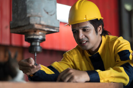Manufacturing industry and factories. Heavy industry machine. Maintenance or repair industrial machine. Asian male factory engineer inspecting or maintenance vertical drilling machine in factory
