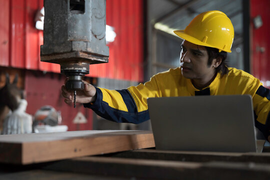 Manufacturing industry and factories. Heavy industry machine. Maintenance or repair industrial machine. Asian male factory engineer inspecting or maintenance vertical drilling machine in factory