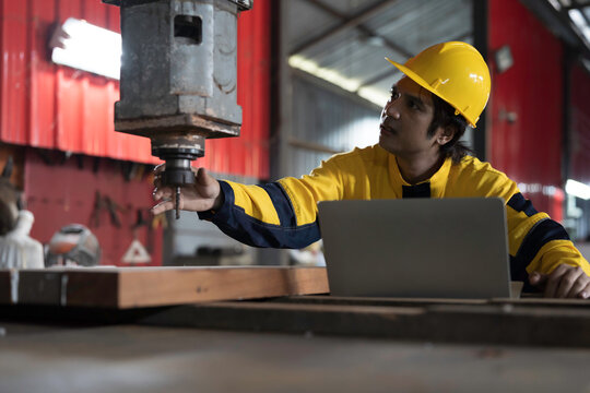 Manufacturing industry and factories. Heavy industry machine. Maintenance or repair industrial machine. Asian male factory engineer inspecting or maintenance vertical drilling machine in factory
