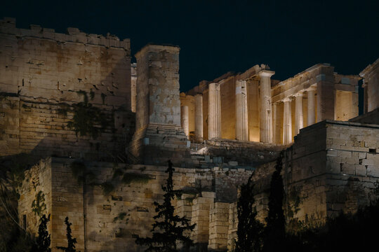 The Acropolis of Athens glows under night lighting, showcasing ancient Greek architecture and timeless stone columns against a dark sky, symbolizing classical heritage and history.
