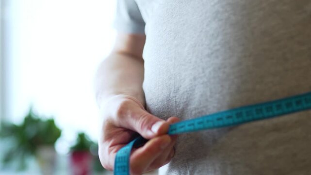 Close Up of Hands Unrolling Measuring Tape
