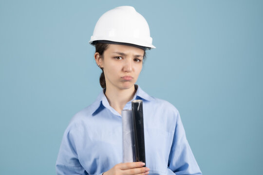 Thoughtful woman engineer holding building blueprint rolled documents