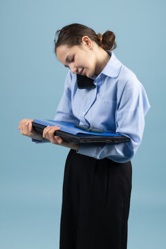 Busy woman talking on mobile smartphone while reading paper folder