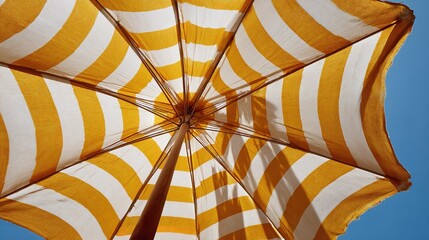 Obraz premium Bright yellow and white stripes dominate the umbrella's canopy.