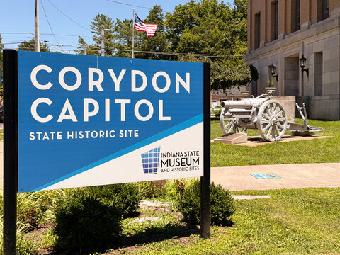 Corydon Capitol, State Historic Site sign with a military cannon in the distance