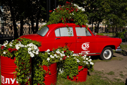 Red vintage soviet car gas-21 volga decorated with blooming flowers in city park. Russia, Moscow 19.07.2026