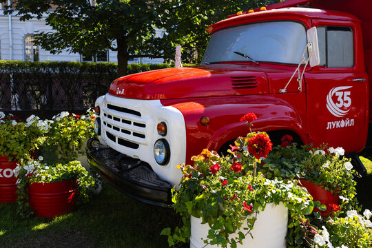 A red vintage truck has been turned into a decorative flower bed with blooming geraniums in a city park. Russia, Moscow 19.07.2026