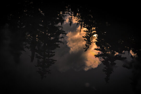 Clouds reflected in dark pool during sunset