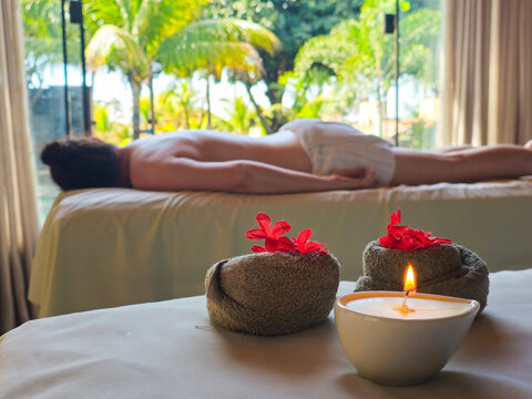 Atmosfera tranquila de spa de luxo com elementos de aromaterapia e terapia de massagem ao fundo.