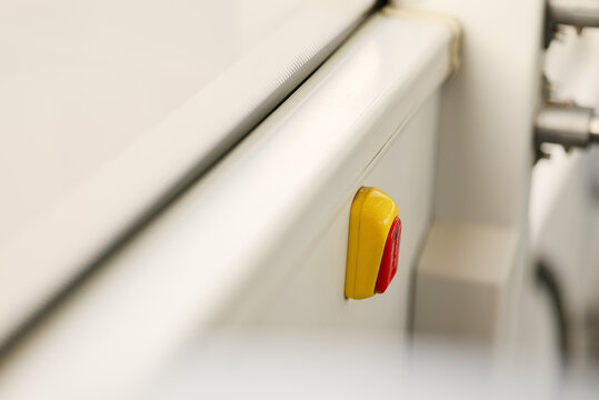 Red and yellow stop request button installed on interior panel near window in public transport vehicle for passenger request signal concepts.