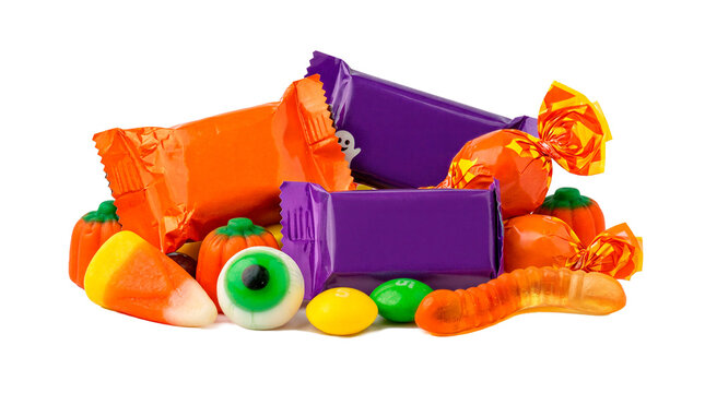 Halloween candy assortment with orange purple wrappers and gummy treats on black background