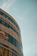Obraz premium Curved stone and glass facade of a modern office building, minimalist architectural detail
