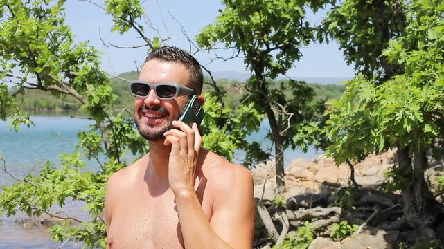 Man calling with his cellphone during the summer time at the beach