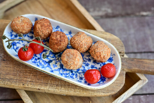 Home made  oven baked meatballs  from  chicken and vegetables and french potato  fries on  wooden background.Bifteki, or spicy meatballs 