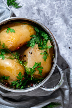 Close up view of hot boiled potatoes with herbs in metal pot